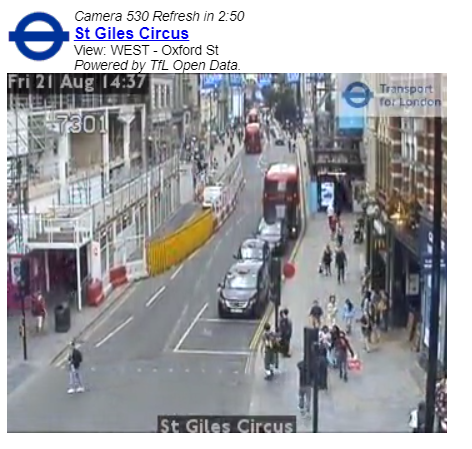 Segment of traffic camera video footage from St Giles Circus in London. Cars, pedestrians and buses are clearly visible in the image.